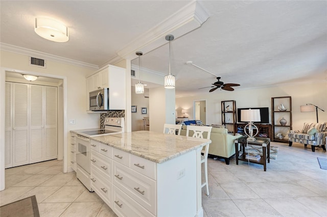 kitchen with white electric range, a breakfast bar, visible vents, white cabinets, and stainless steel microwave