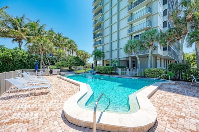 community pool with fence and a patio