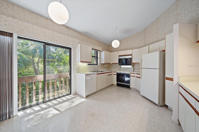 1654 Starling Dr Unit 201, Sarasota, FL 34231 - kitchen featuring white appliances, lofted ceiling, light countertops, light floors, and a sink