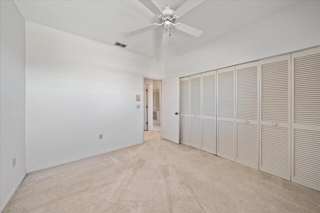 1654 Starling Dr Unit 201, Sarasota, FL 34231 - unfurnished bedroom featuring a closet, visible vents, light carpet, ceiling fan, and a textured ceiling