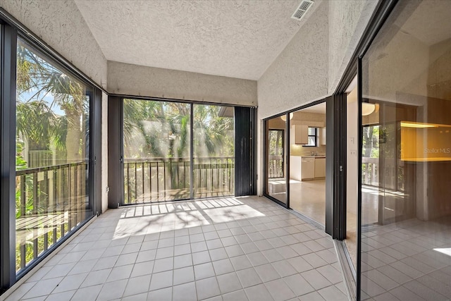 1654 Starling Dr Unit 201, Sarasota, FL 34231 - unfurnished sunroom with lofted ceiling, visible vents, and a healthy amount of sunlight