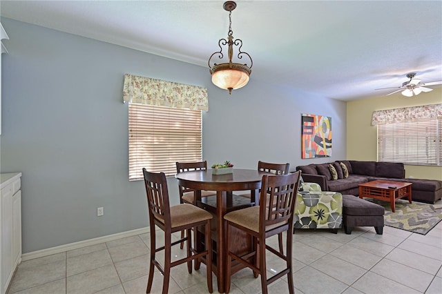 tiled dining space with ceiling fan and plenty of natural light