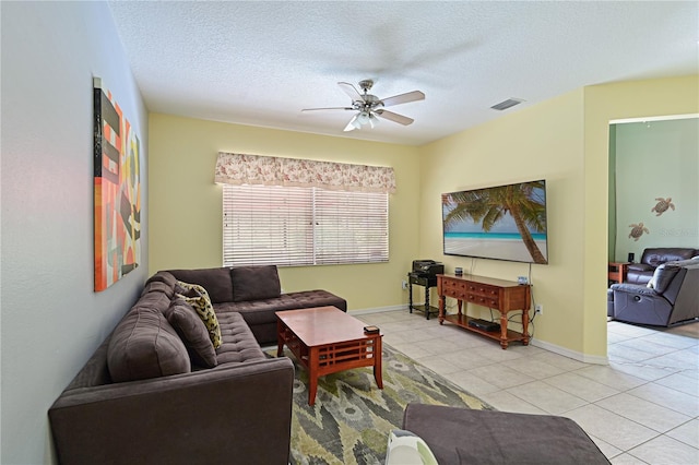 tiled living room featuring ceiling fan and a textured ceiling