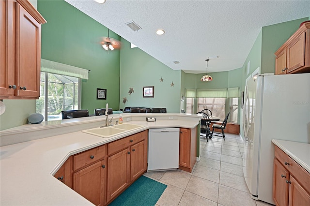 kitchen with sink, kitchen peninsula, pendant lighting, white appliances, and light tile patterned floors