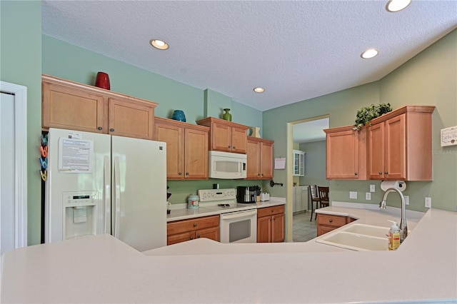 kitchen with a textured ceiling, white appliances, and sink