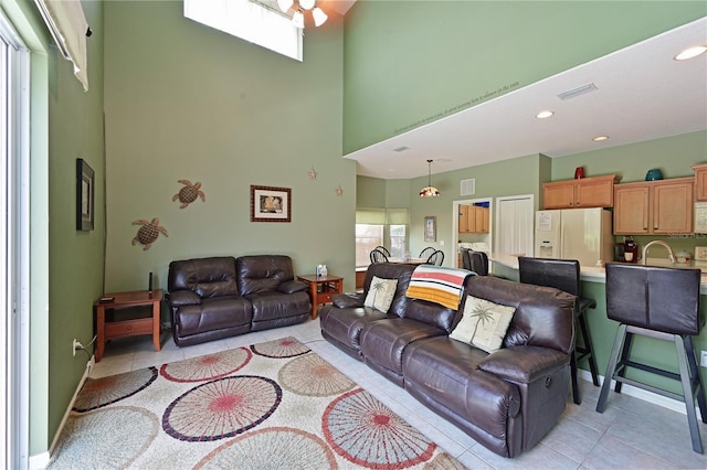 tiled living room with a towering ceiling and sink