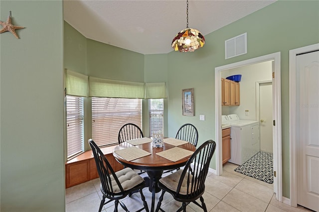 tiled dining space featuring washing machine and dryer and a textured ceiling