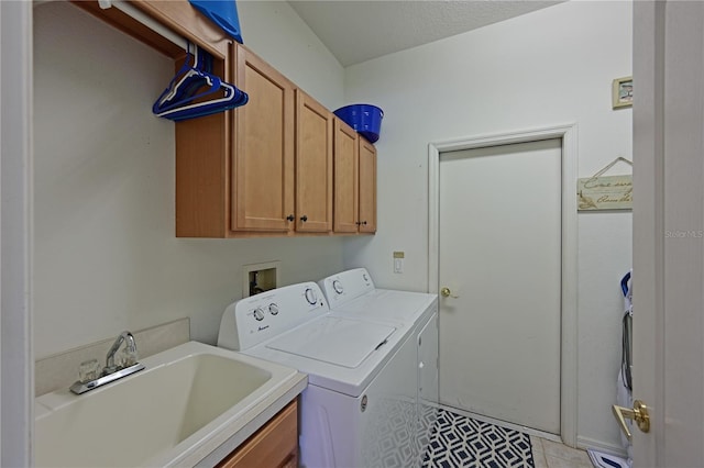 laundry area with sink, cabinets, a textured ceiling, washer and clothes dryer, and light tile patterned floors