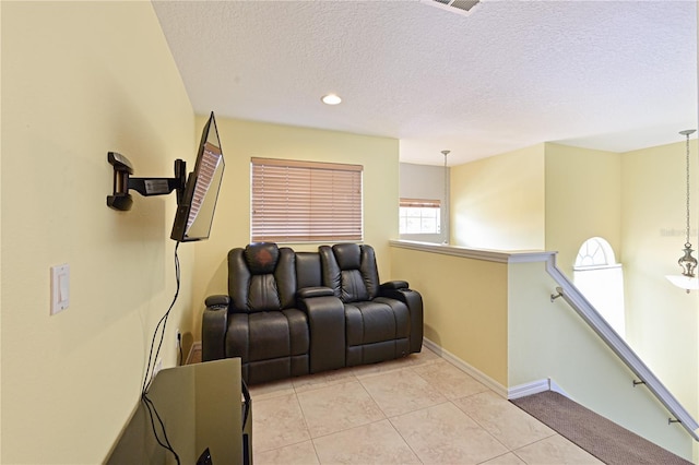 tiled home theater room with a textured ceiling