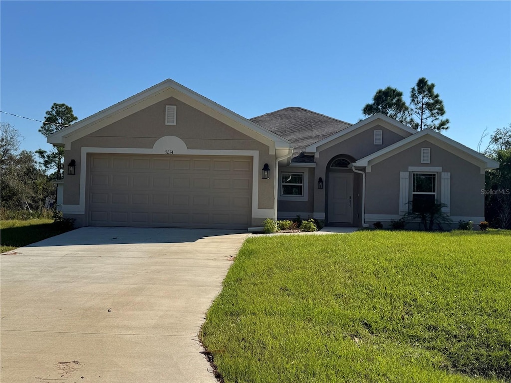 ranch-style home featuring a garage and a front yard