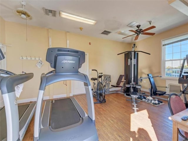 exercise room with wood finished floors, visible vents, and ceiling fan