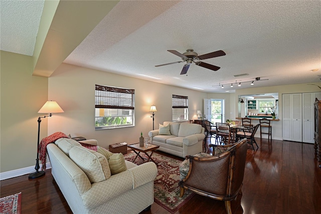 living room featuring visible vents, a textured ceiling, ceiling fan, and hardwood / wood-style flooring