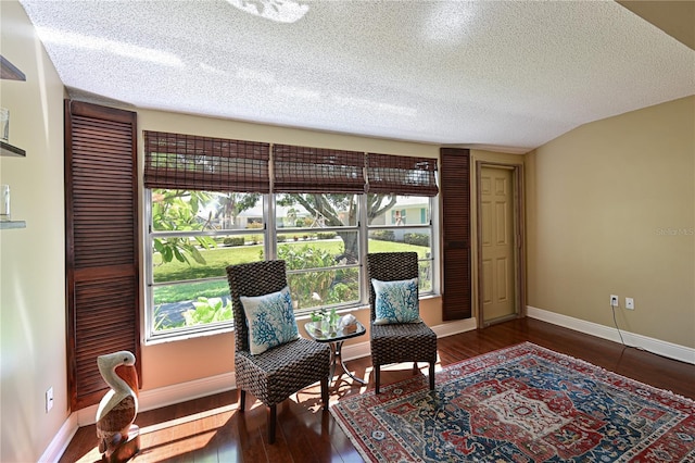 living area featuring baseboards, a textured ceiling, and wood finished floors