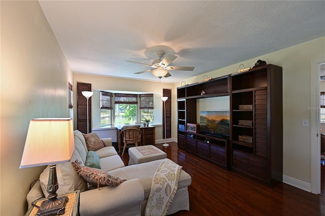 living area with a ceiling fan, wood finished floors, baseboards, and a textured ceiling