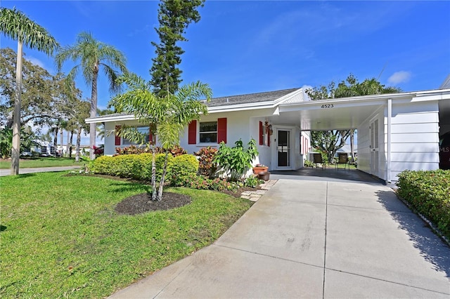 view of front facade with stucco siding, a carport, concrete driveway, and a front yard