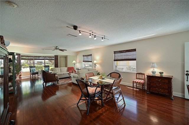 dining space with visible vents, baseboards, a textured ceiling, and dark wood finished floors