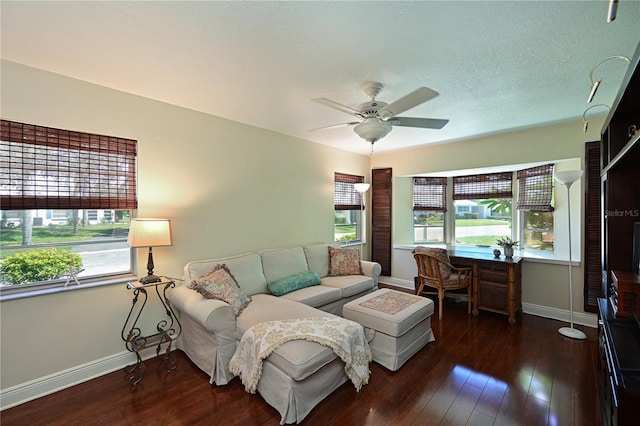 living room with baseboards, wood-type flooring, a textured ceiling, and ceiling fan