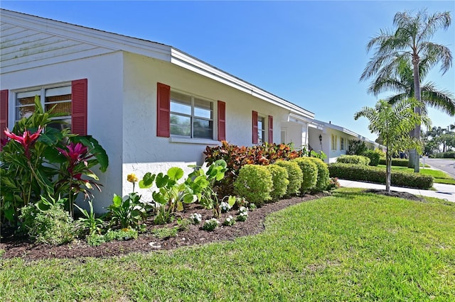 view of home's exterior featuring stucco siding and a lawn