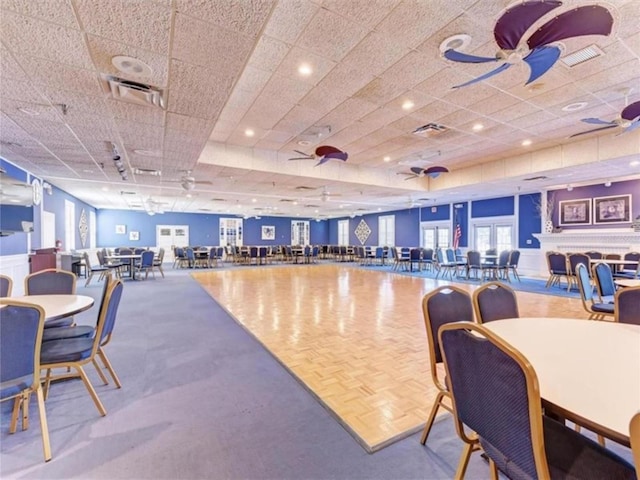 interior space featuring visible vents, a drop ceiling, and ceiling fan