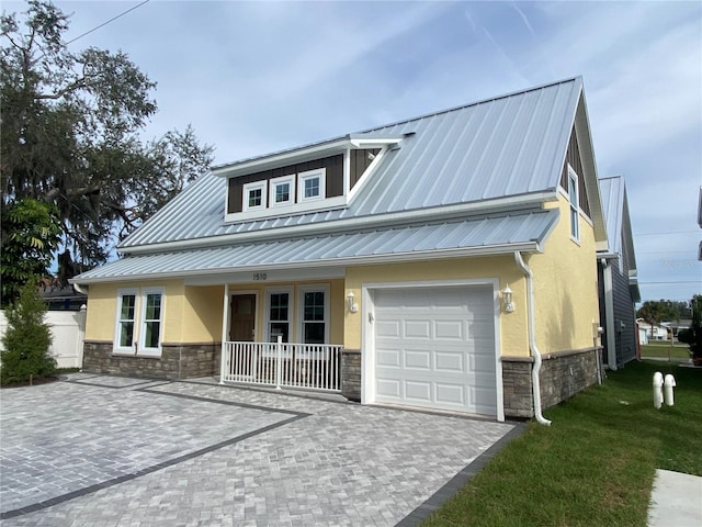 view of front of home with covered porch, a front lawn, and a garage