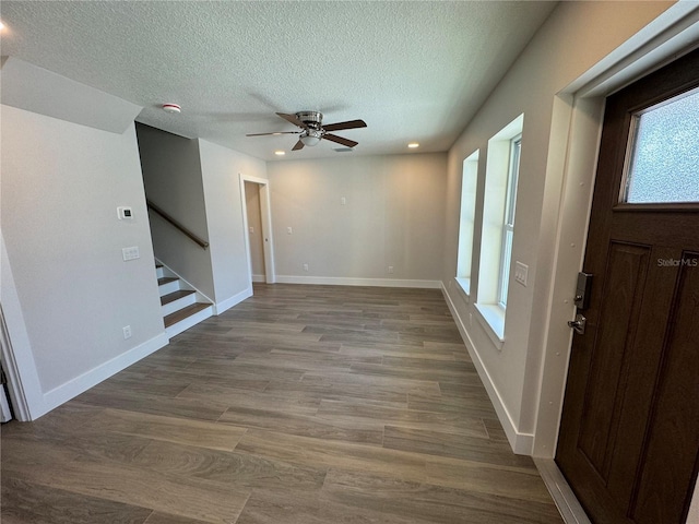 foyer featuring dark hardwood / wood-style flooring, a textured ceiling, ceiling fan, and a wealth of natural light