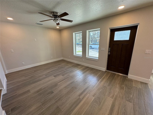 foyer featuring a textured ceiling, ceiling fan, and dark wood-type flooring