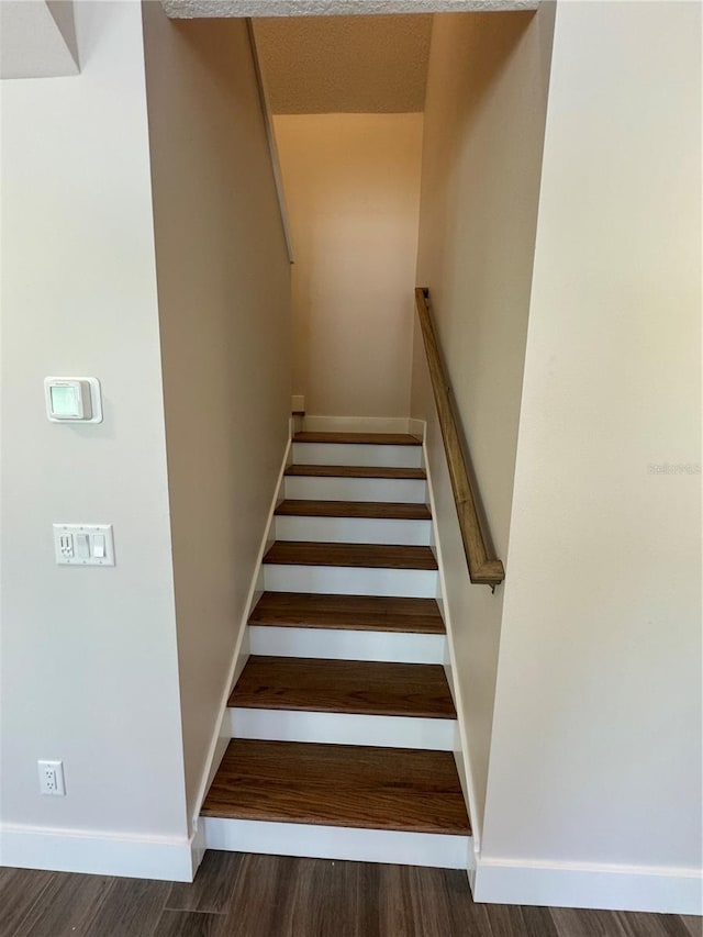 staircase featuring dark hardwood / wood-style floors