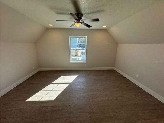 bonus room featuring vaulted ceiling, ceiling fan, a textured ceiling, and dark hardwood / wood-style flooring