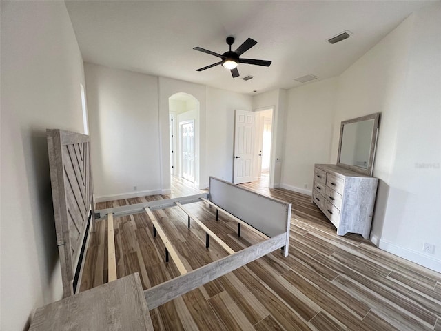 unfurnished bedroom with ceiling fan and wood-type flooring