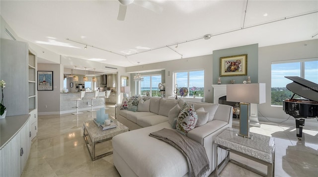 living room featuring ceiling fan with notable chandelier and rail lighting