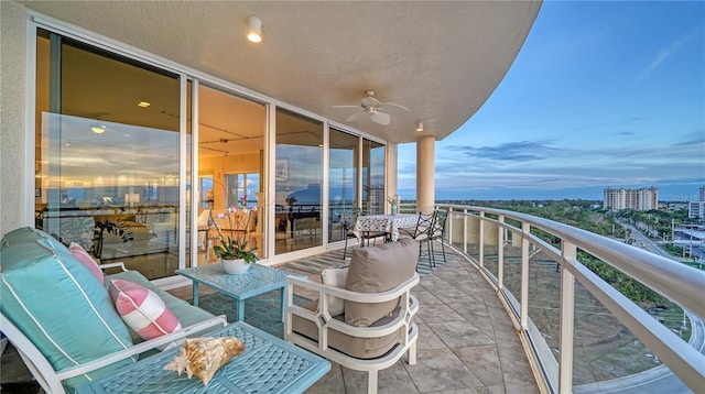 balcony at dusk featuring ceiling fan