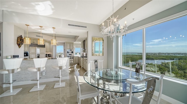 dining space with a water view and an inviting chandelier