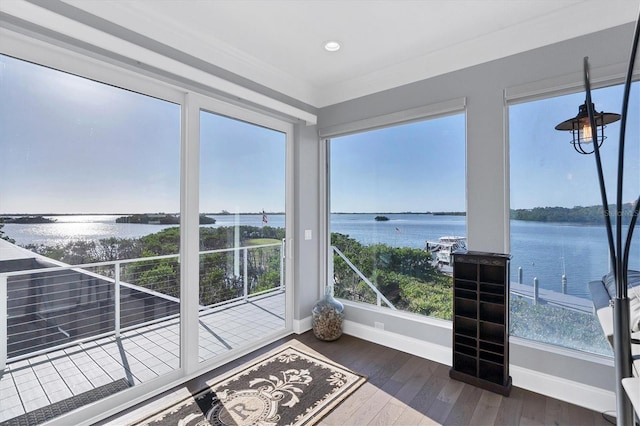 unfurnished sunroom featuring a water view