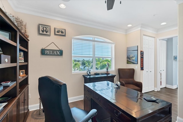 office area with dark wood-type flooring, ceiling fan, and ornamental molding