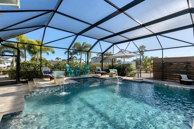 view of pool featuring pool water feature, an in ground hot tub, a patio area, and glass enclosure