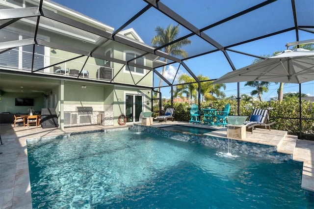 view of pool with pool water feature, glass enclosure, an in ground hot tub, exterior kitchen, and a patio