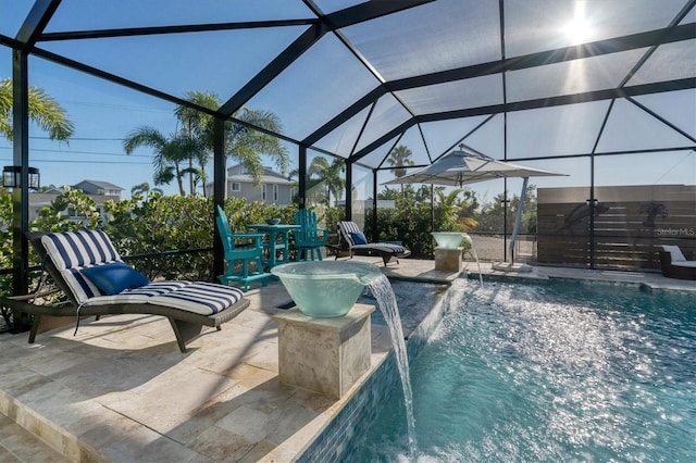 view of pool with a patio, pool water feature, and glass enclosure