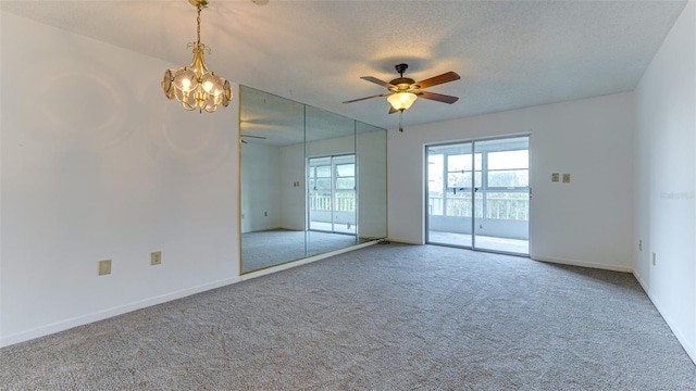 unfurnished room with ceiling fan with notable chandelier, carpet floors, and a textured ceiling