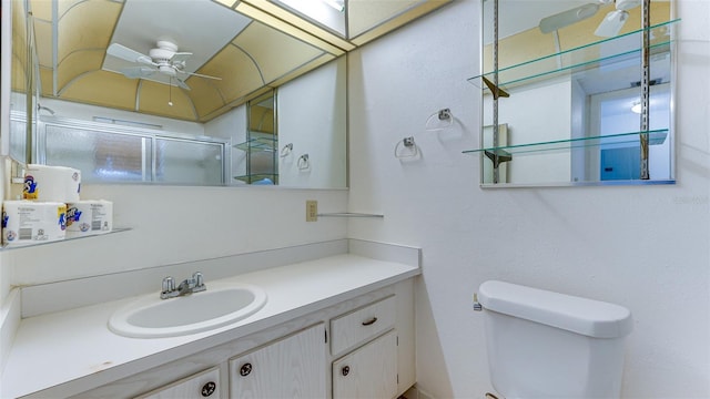 bathroom with ceiling fan, vanity, toilet, and a shower with shower door