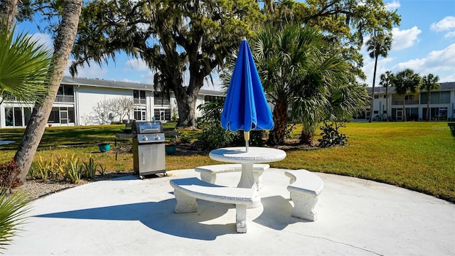 view of property's community with a lawn and a patio area