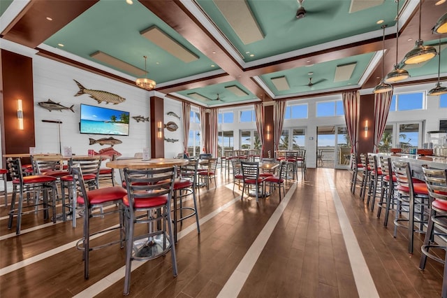 interior space featuring ceiling fan, hardwood / wood-style floors, a towering ceiling, and a healthy amount of sunlight