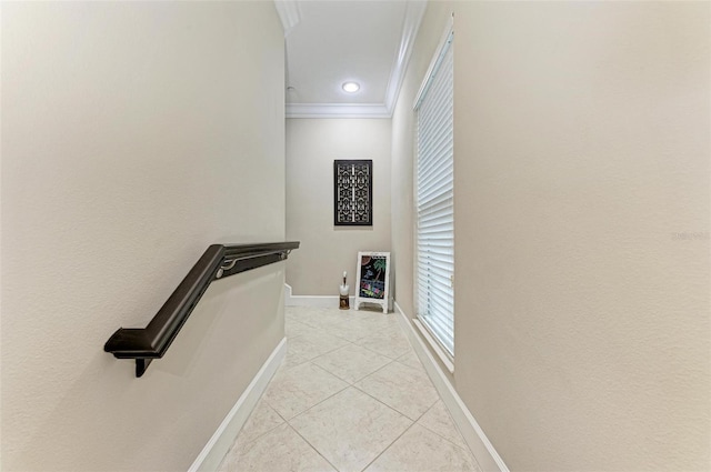 corridor with light tile patterned floors and crown molding