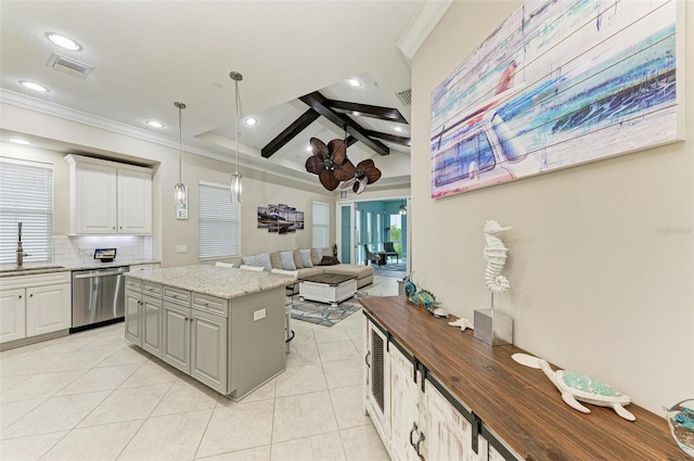 kitchen with decorative light fixtures, light stone countertops, a kitchen island, stainless steel dishwasher, and white cabinets