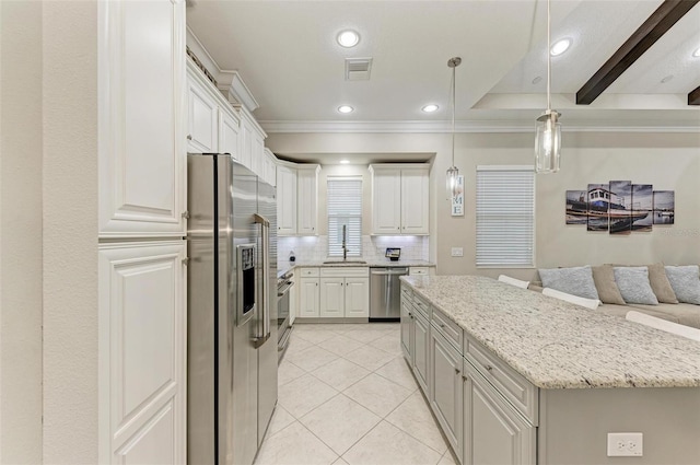 kitchen featuring decorative backsplash, white cabinetry, hanging light fixtures, appliances with stainless steel finishes, and light stone counters