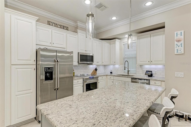 kitchen featuring decorative light fixtures, backsplash, sink, stainless steel appliances, and white cabinets