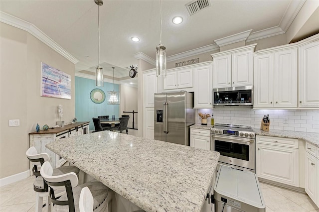 kitchen with decorative light fixtures, white cabinets, a center island, and high quality appliances