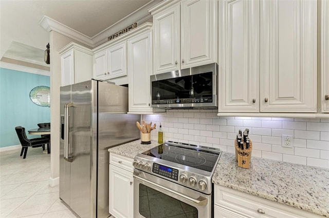 kitchen featuring light tile patterned floors, white cabinetry, stainless steel appliances, backsplash, and ornamental molding