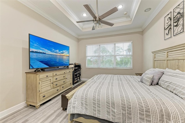 bedroom featuring ceiling fan, crown molding, a tray ceiling, and light hardwood / wood-style floors