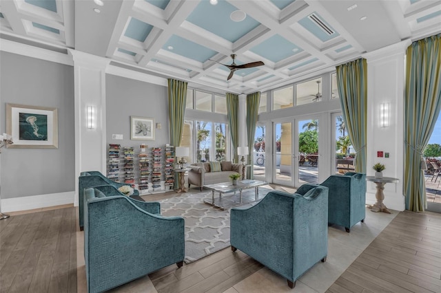 living room featuring coffered ceiling, ceiling fan, a towering ceiling, french doors, and beam ceiling