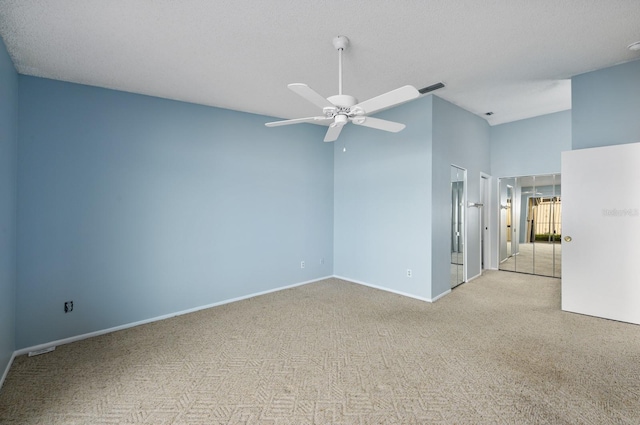 carpeted spare room featuring a textured ceiling and ceiling fan